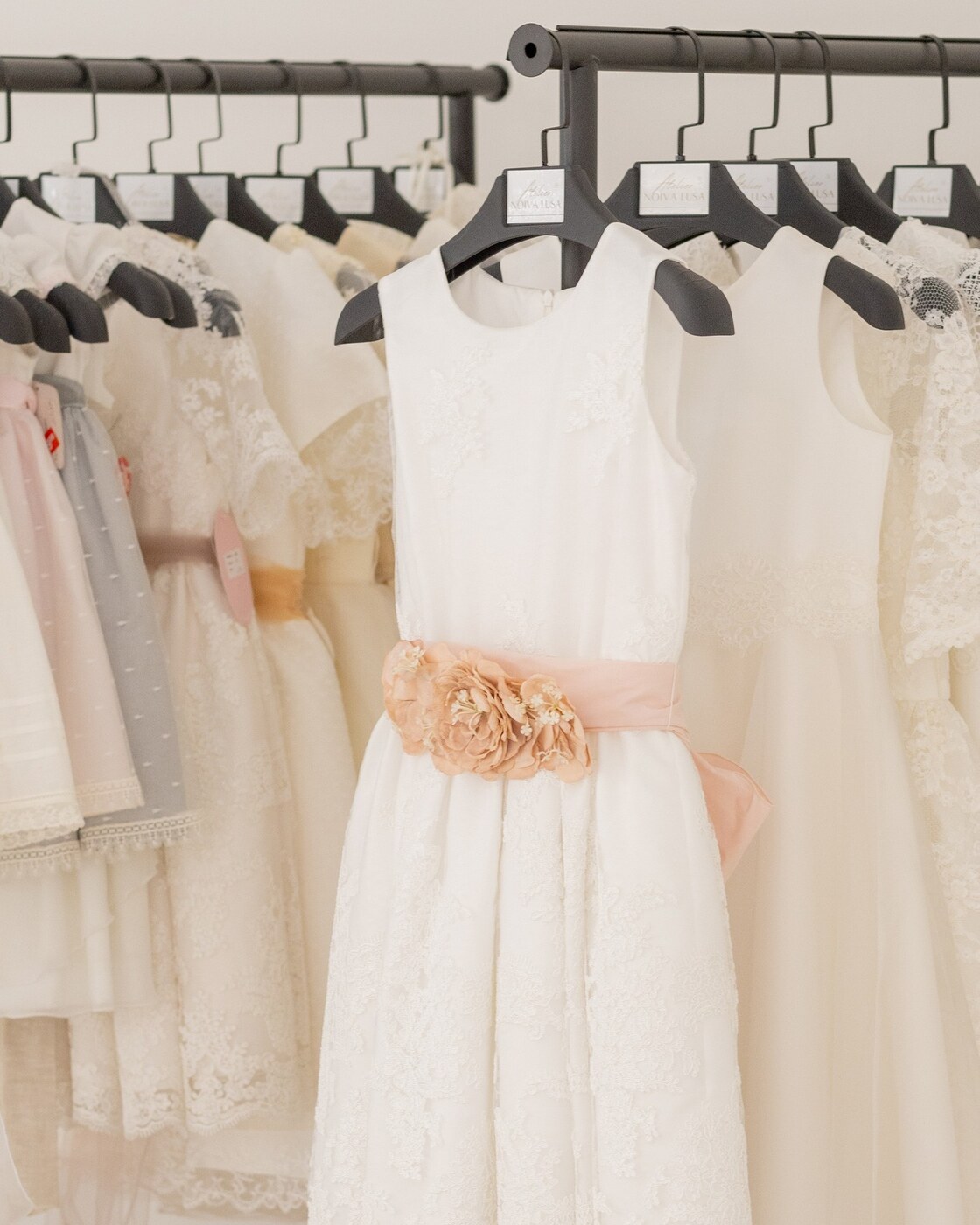 Mãos de consultora a ajustar a cauda de um vestido, atelier Noiva Lusa
